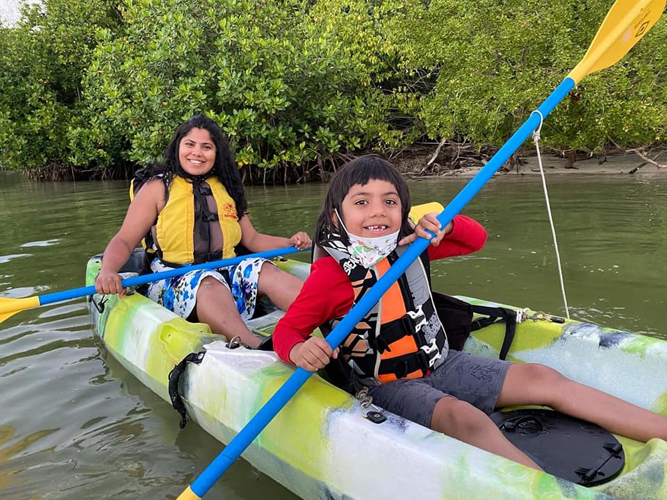 Mom and son kayak along a river in Puerto Rico, one of the best hot places to visit in December with kids!