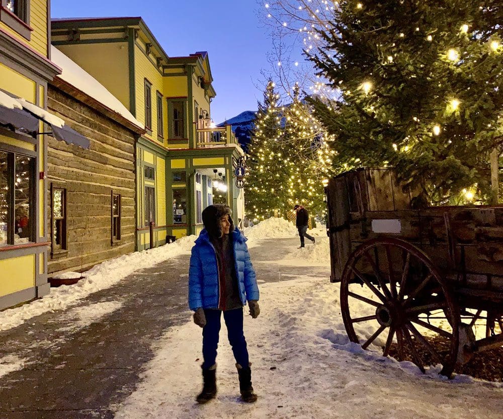 A young boy stands on a street in Breckenridge during the holidays.