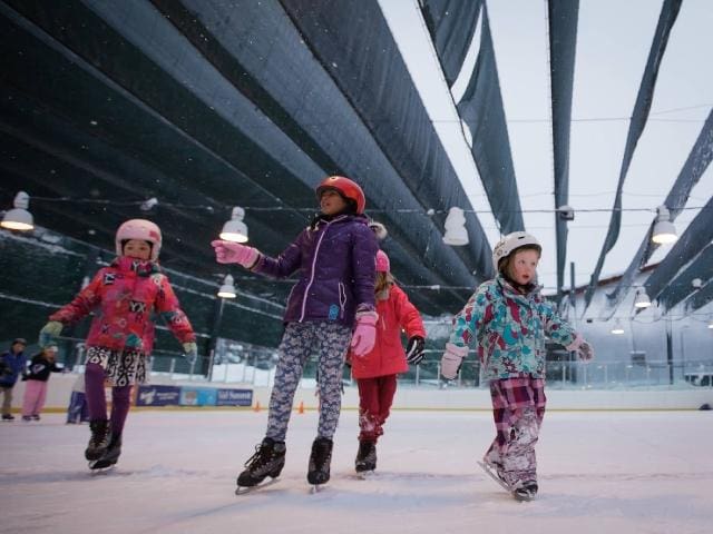 Four kids ice skate along at the STEPHEN C WEST ICE ARENA in Breckenridge.