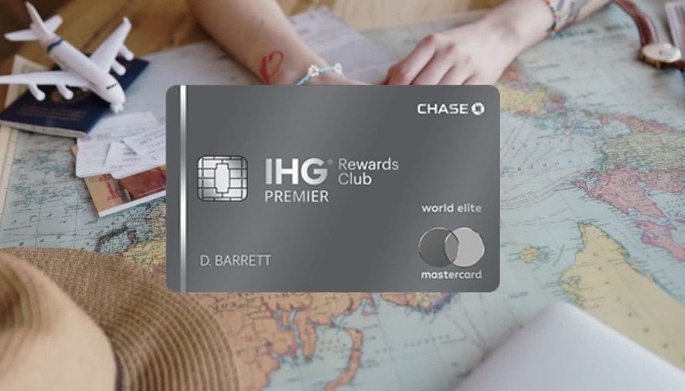 A close up of the MasterCard IHG Reward Club Premier credit card, nestled on a background of kid's hands playing with a toy airplane and map.