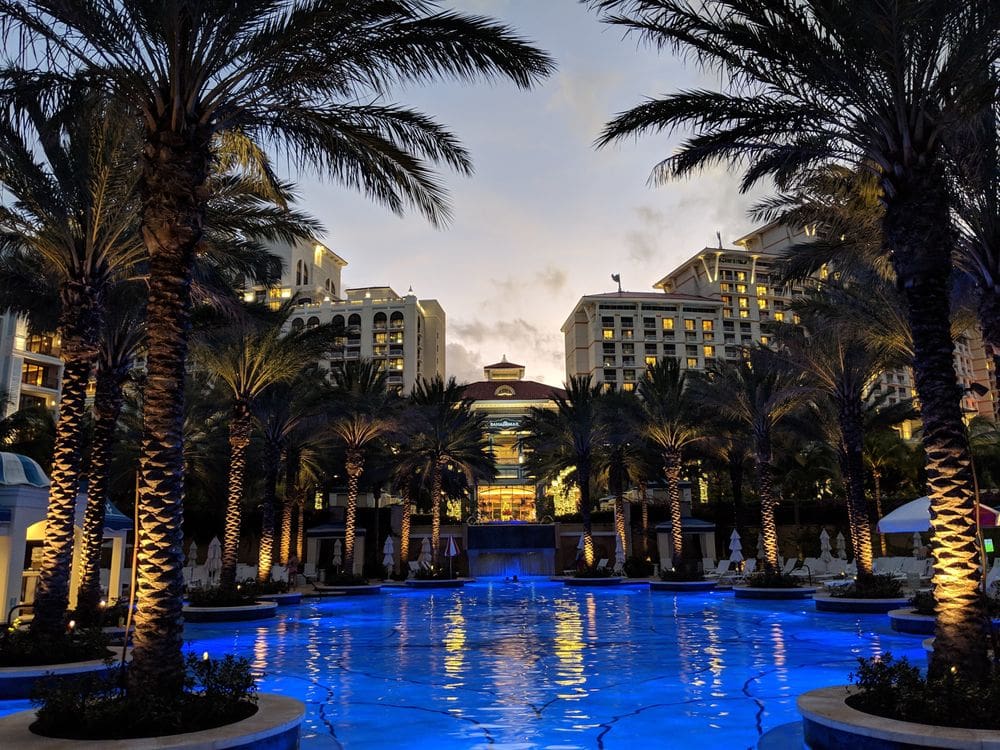 A view of the pool, palms, and grounds of Hyatt Baha Mar at dusk.
