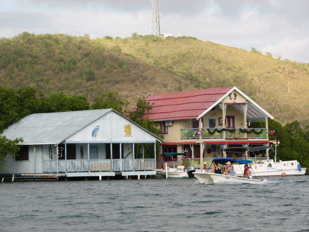 A boat drives by two homes in La Pargüera, Lajas, Puerto Rico.