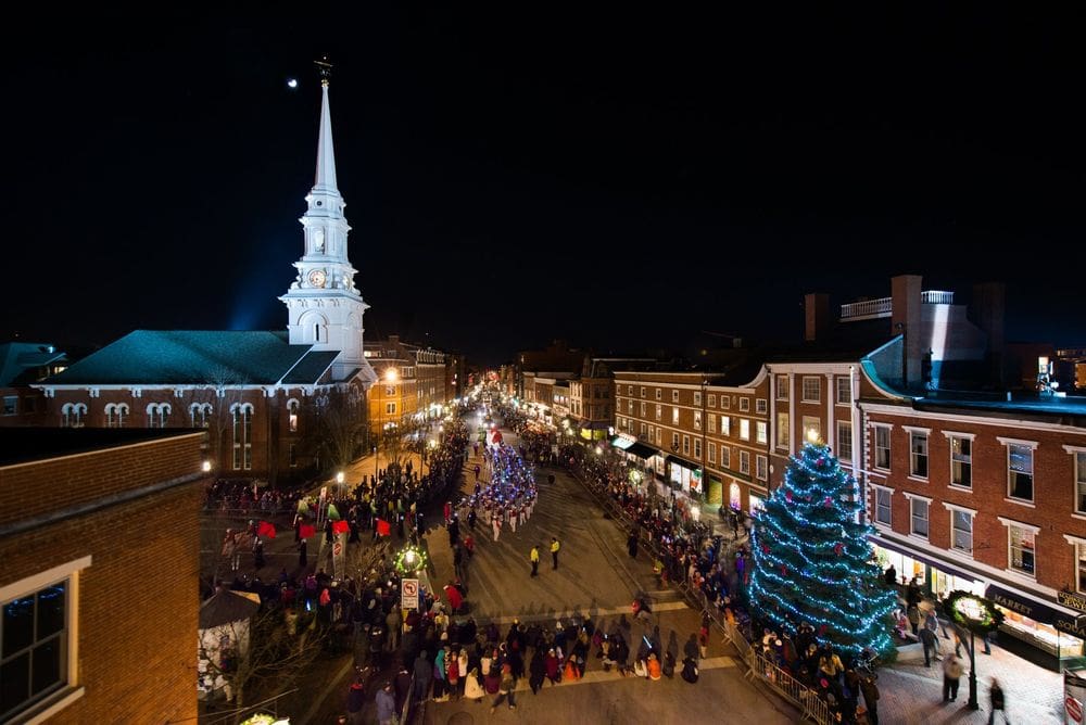 An aerial view of Portsmouth during Christmas, featuring a large Christmas tree and parade with onlookers.