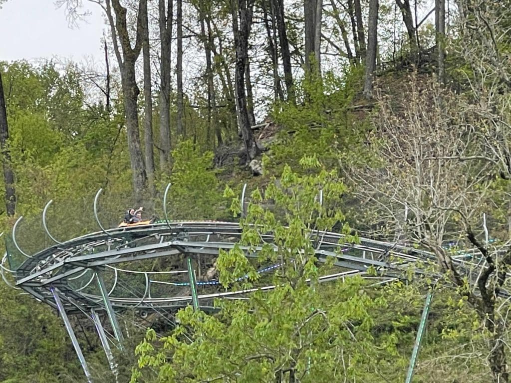 A mom and her small boy race around an alpine coaster, one of the best things in a family itinerary for Gatlinburg Pigeon-Forge.