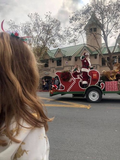 A young girl looks at Santa, riding in a sleigh in a parade in Solvang, California.