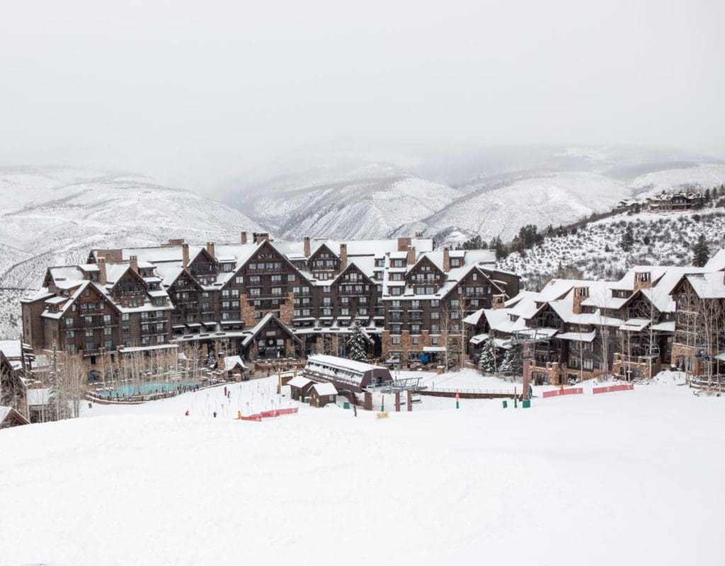 The exterior of the The Ritz-Carlton, Bachelor Gulch, with snow on the roofs and ground.