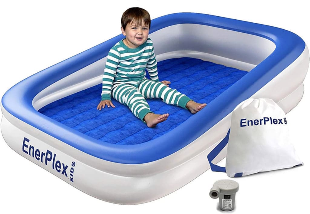 A product shot of a toddler boy sitting in a blue and white EnerPlex Kids Inflatable Travel Bed.