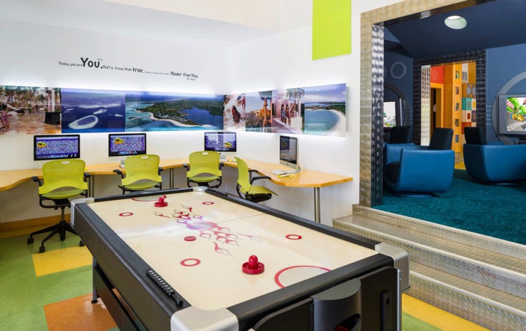 Inside the teen room at The Ocean Club, featuring an air hockey table and several computers.