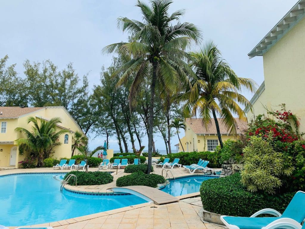 A view of the pool and pool deck, lush with palm trees, at the Sunrise Beach Villas.