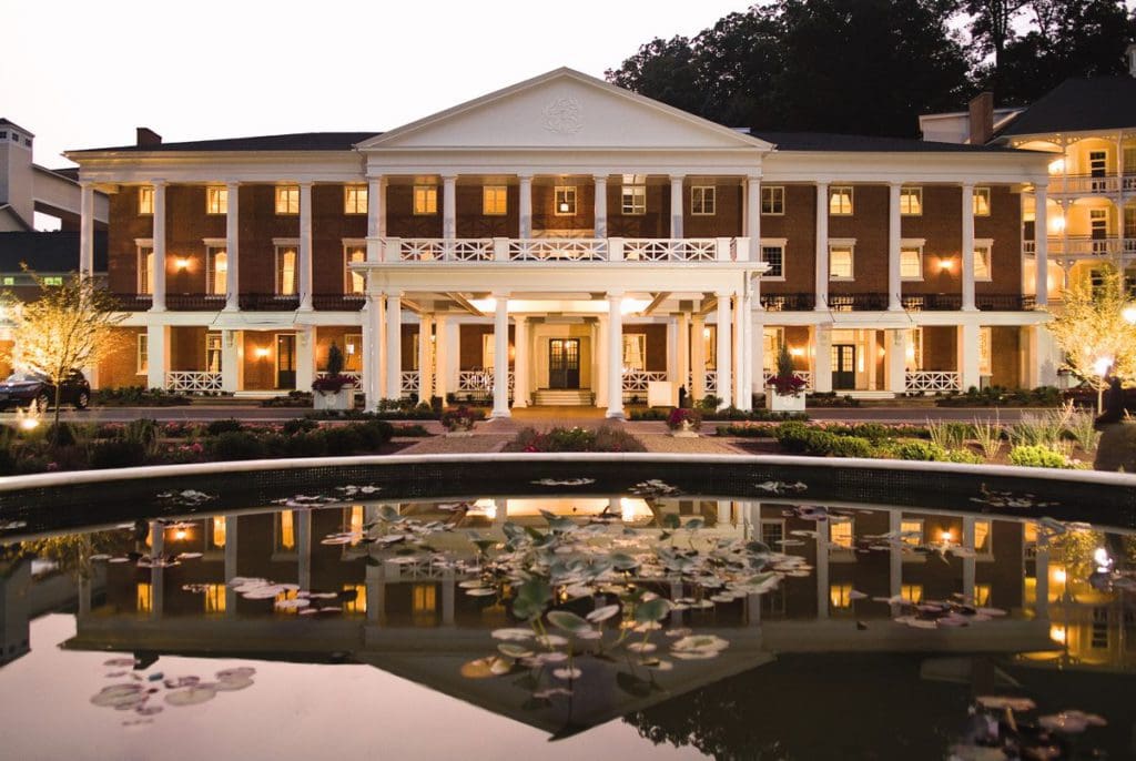 The exterior entrance to the Omni Bedford Springs Resort at dusk, across from the driveway pond, one of the best resorts in Pennsylvania for families.