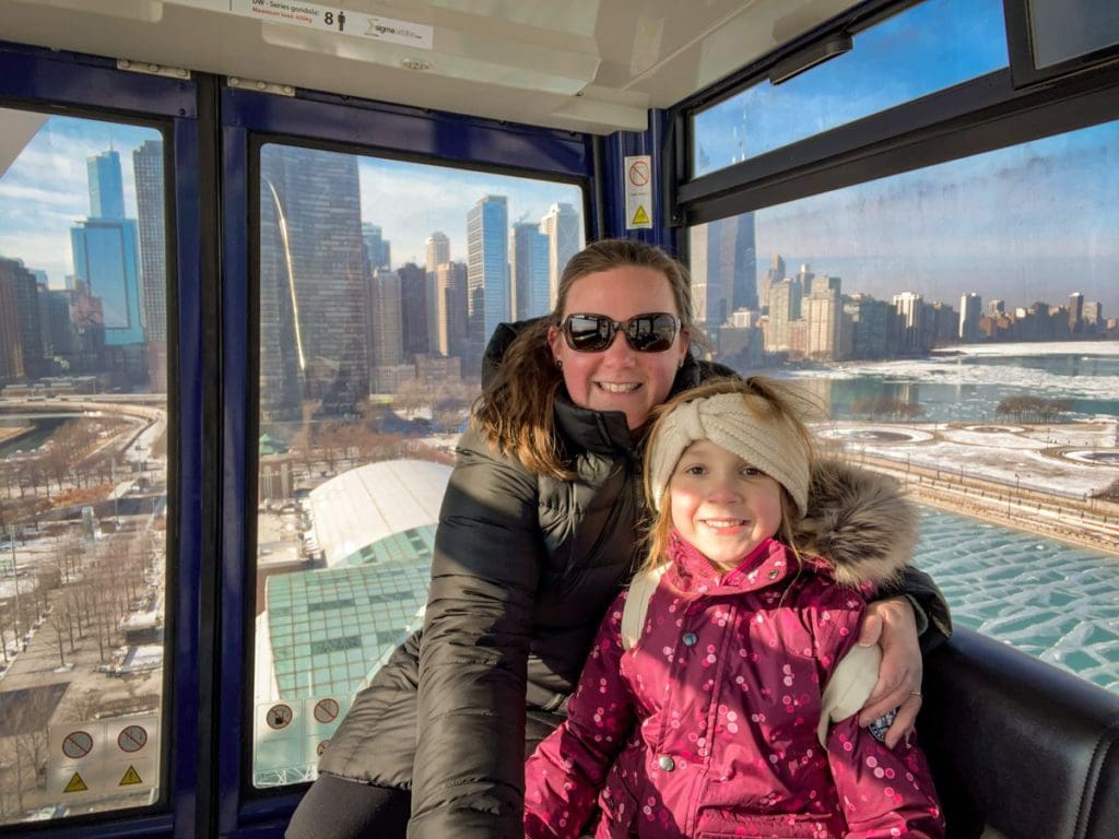 A young girl and her mom ride in the Centennial Wheel together, while visiting Chicago, one of the best places to visit with your young daughter in America.