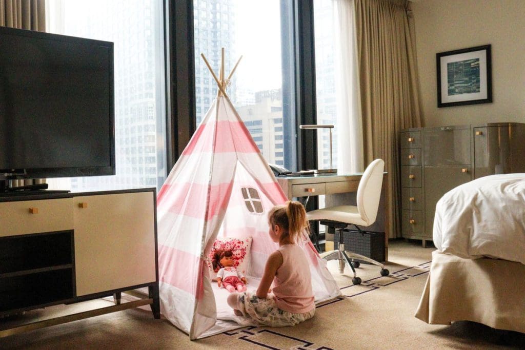 A young girl plays in a cozy, pink in-room tent at The Langham, Chicago.