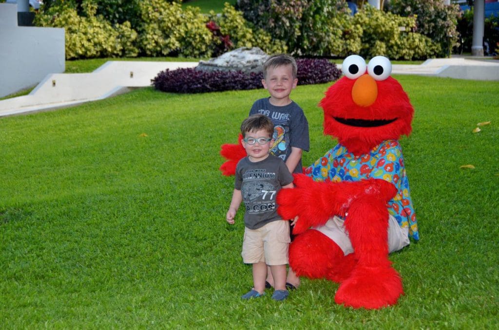 Two boys stand near Elmo at Beaches Ocho RIos.