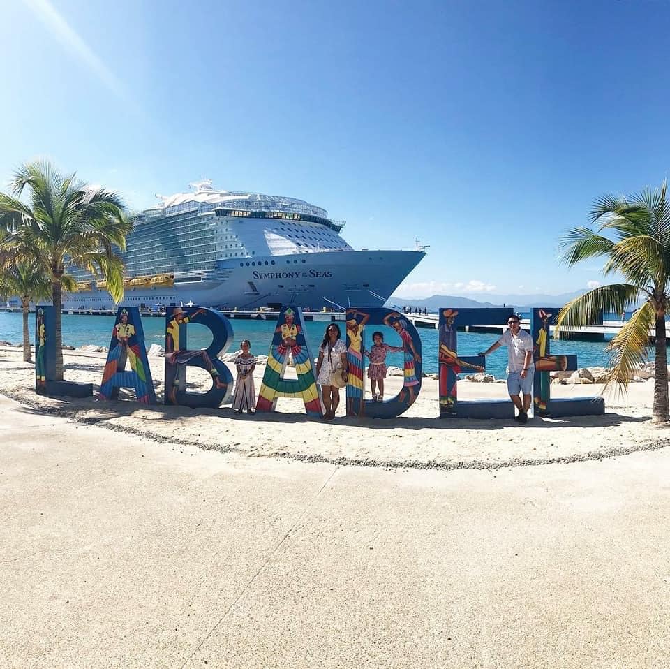 A family of four stands amongst large letters reading Labadee, while on a Royal Caribbean Cruise, one of the best cruise lines for families.