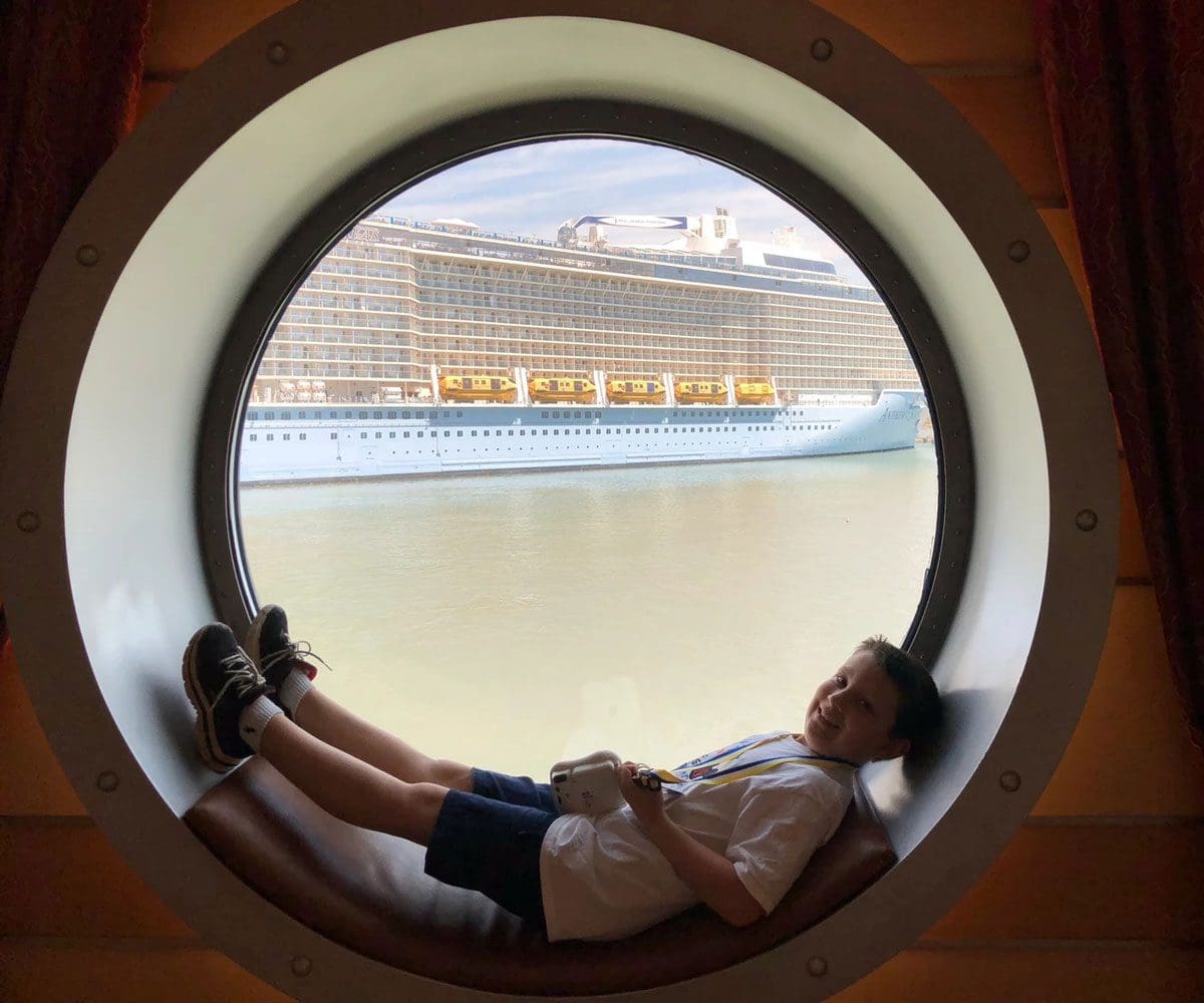 A young boy lays in a port window on a Disney Cruise.