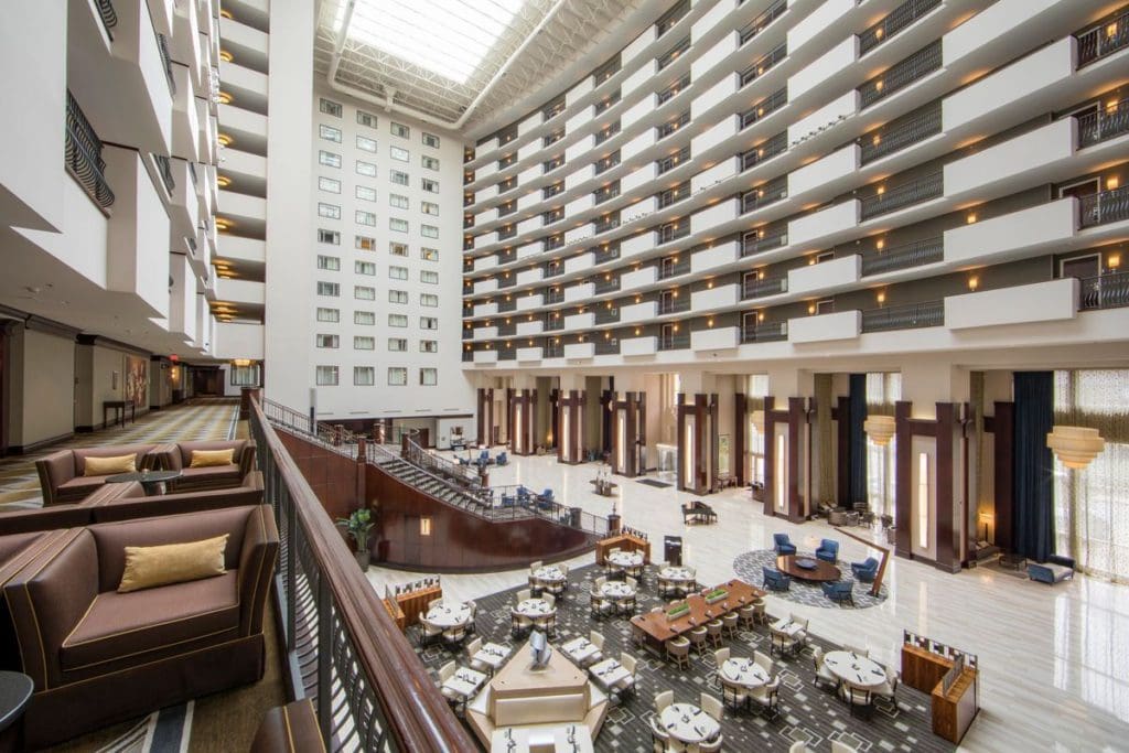 Inside the two-story lobby of the Hilton Nashville Downtown, featuring plush furniture and bright lighting.