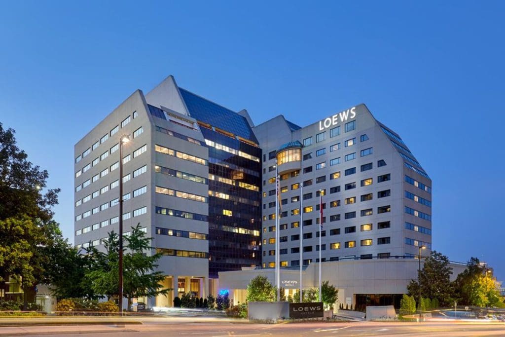 A view of the Loews Vanderbilt Hotel at dusk, will illuminated lettering spelling "LOEWS" on the top of the hotel.