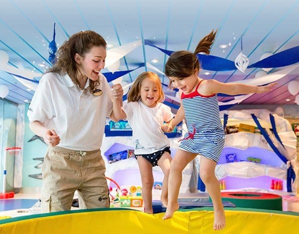Two kids play in the kids' club on a MSC Cruise ship with a staff member.
