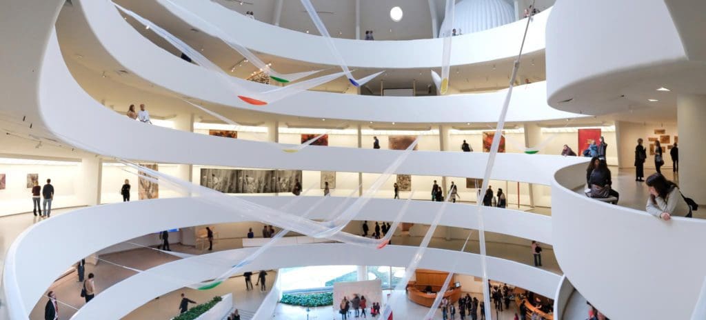 A view inside The Solomon R Guggenheim Museum, featuring a hanging art installation over the grand entrance.