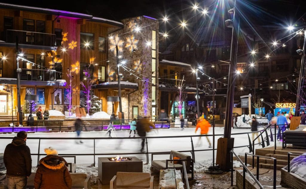 Several people go ice skating at an outdoor rink near Snowmass, one of the best things to do when visiting Aspen during the winter with kids.