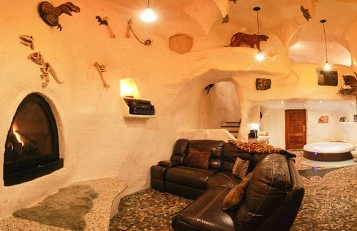 Inside the cave-themed room at Adventure Suites, featuring cave-like walls, dinosaur skeletons, and other cave-themed furnishings.