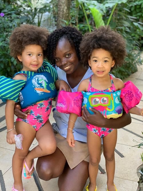 A nanny at Franklyn D. Resort & Spa hugs two kids in swimwear. 