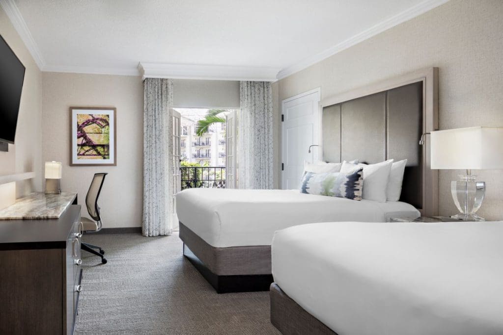 Inside one of the guest rooms at Gaylord Opryland Resort & Convention Center, featuring two double beds, an interior balcony, and desk area.