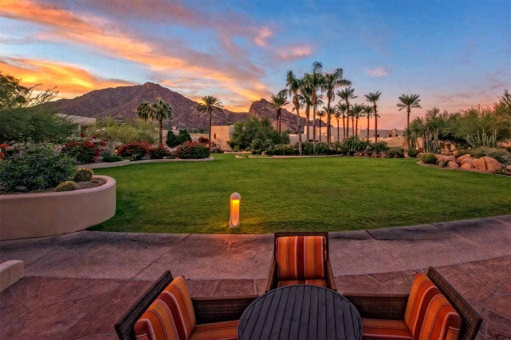 The large green-space outside of JW Marriott Scottsdale Camelback Inn Resort & Spa, with a small seating area, at dusk.
