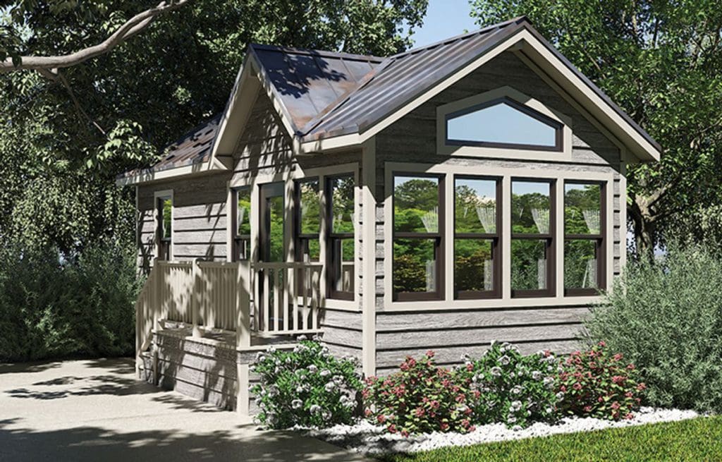 One of the cabins, featuring large windows, nestled amongst the trees at Jellystone Park in California.