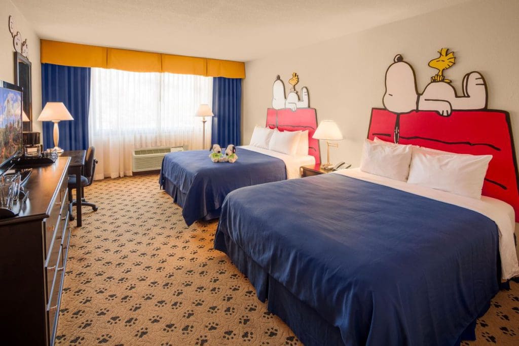 One of the Snoopy-themed room at Knotts Berry Farm Hotel, featuring red and blue colors with Snoopy sitting on the pillows.