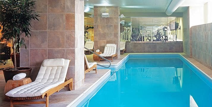 The indoor pool at Loews New Orleans, featuring plush nearby seating.