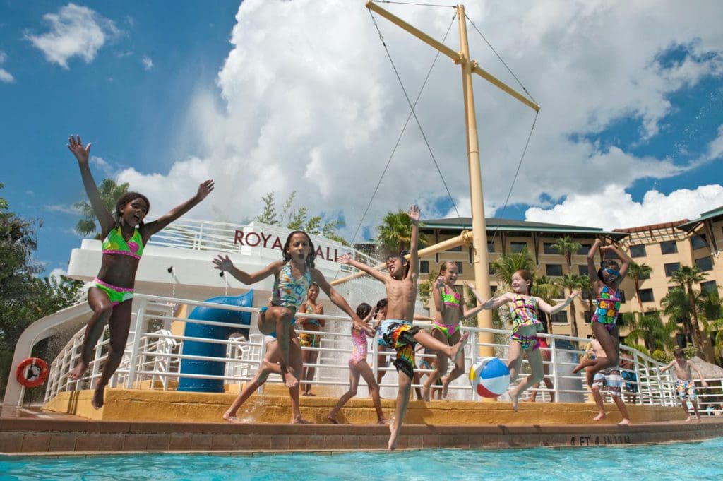 Several kids jump from a play pirate ship at the children's pool at Loews Royal Pacific Resort.