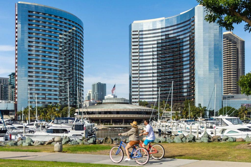 Two people on bikes pass the Marriott Marquis San Diego Marina.