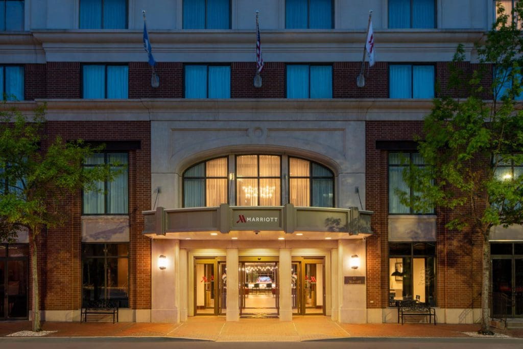 The grand, stone entrance to the New Orleans Marriott Warehouse Arts District, well-lit at night, one of the best hotels in New Orleans for families.