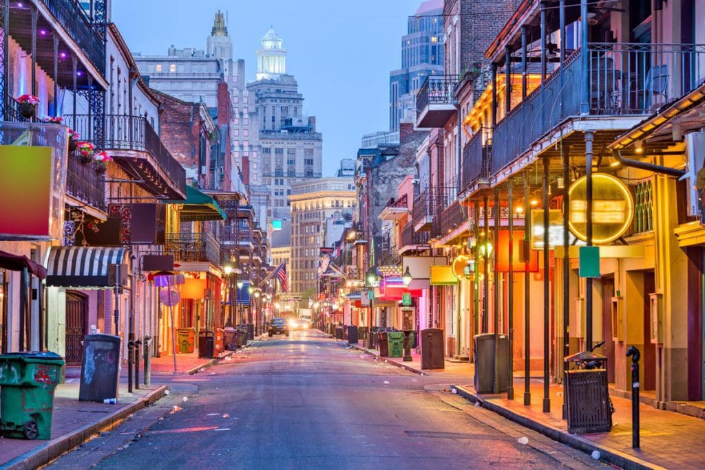 A well-lit street in New Orleans at night, featuring shops and other store fronts.