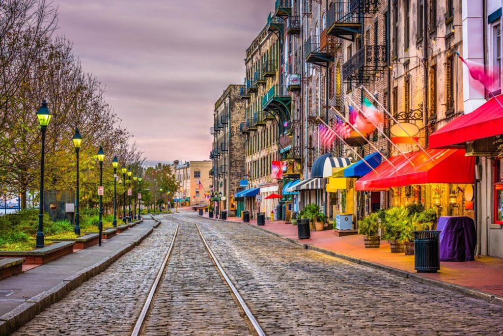 Savannah's River Street, featuring the iconic cobblestones and historic shop fronts. It's one of the best places for an East Coast road trip for families. 