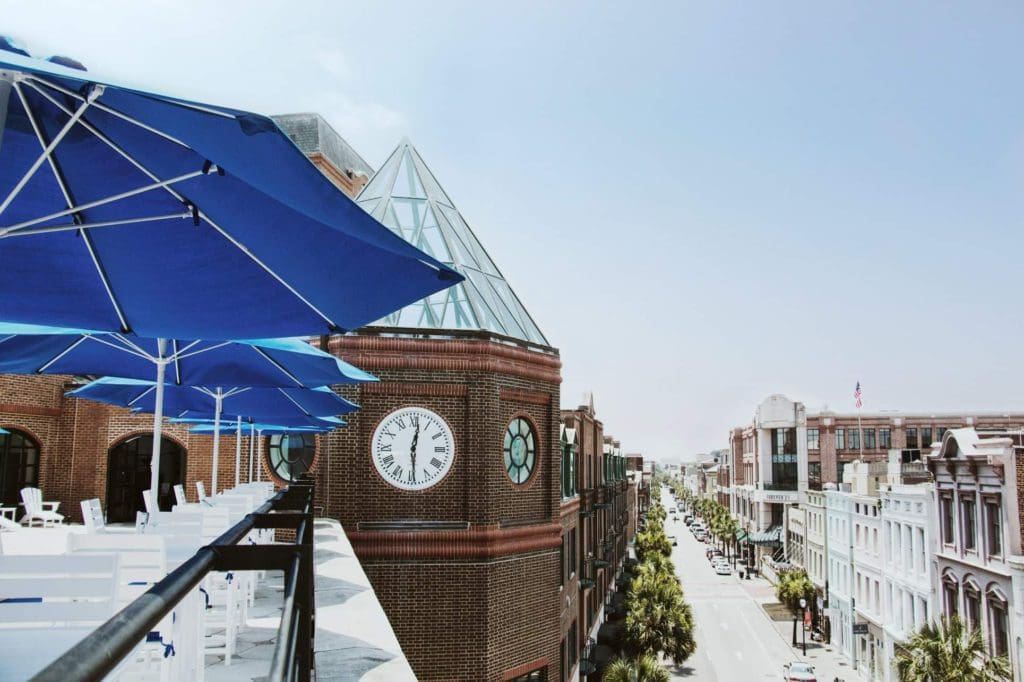 A view of the Charleston Place, A Belmond Hotel terrace, featuring a view of downtown Charleston.