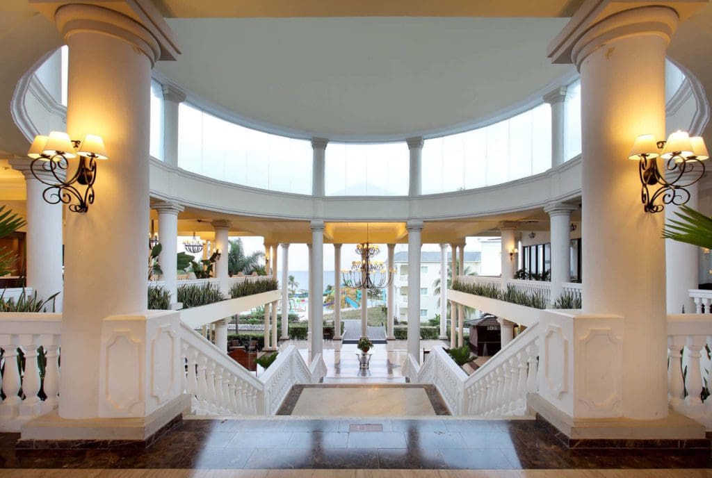 The grand lobby of the Grand Palladium Jamaica Resort & Spa, featuring off-white hues and a tropical luxury vibe.
