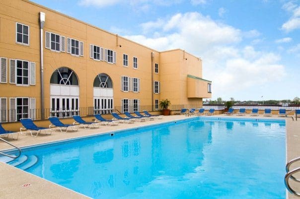 The terrace pool at Hilton New Orleans Riverside, featuring a line of poolside loungers and sunny sky.