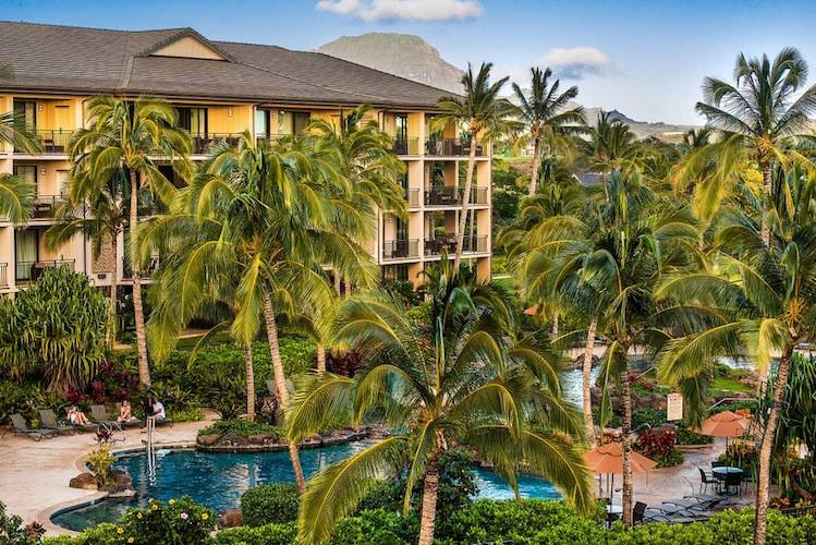 The resort buildings through swaying palms trees at Koloa Landing Resort At Poipu.