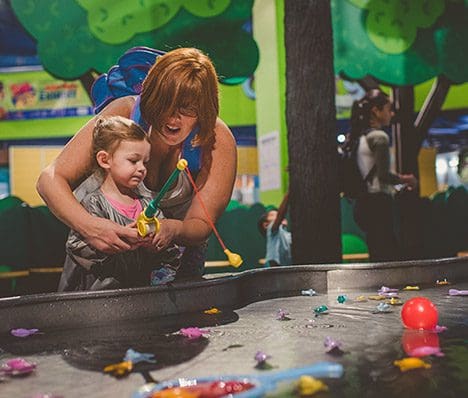 A mom and her young child play in the water feature exhibit at Children's Museum of Atlanta.