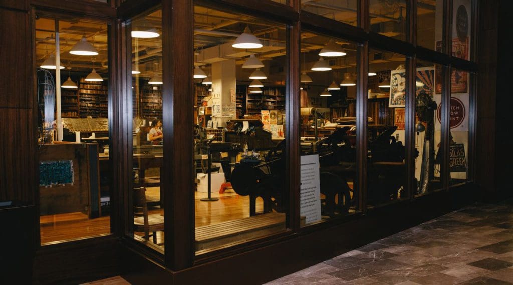 Looking through the windows into Hatch Print Shop, one of the best things to do in Nashville with kids, featuring large printing equipment.