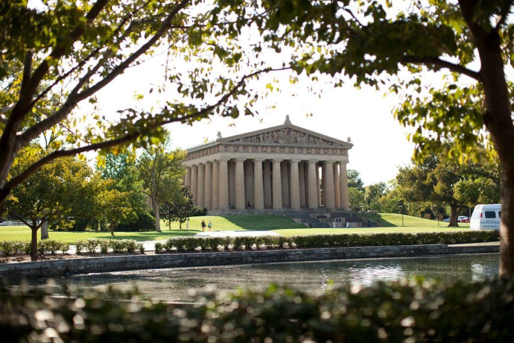 Across a tranquil pond, the Nashville Parthenon can be seen on a beautiful spring day.