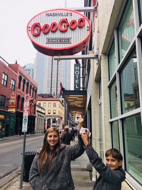 Two kids excitedly hold up their treats in front of Goo Goo in Nashville.