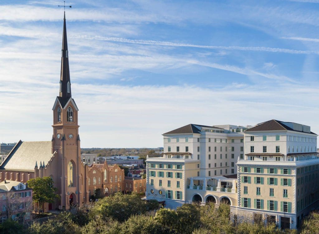 Hotel Bennett proudly standing in the center of Charleston, with the nearby church flanking one side.