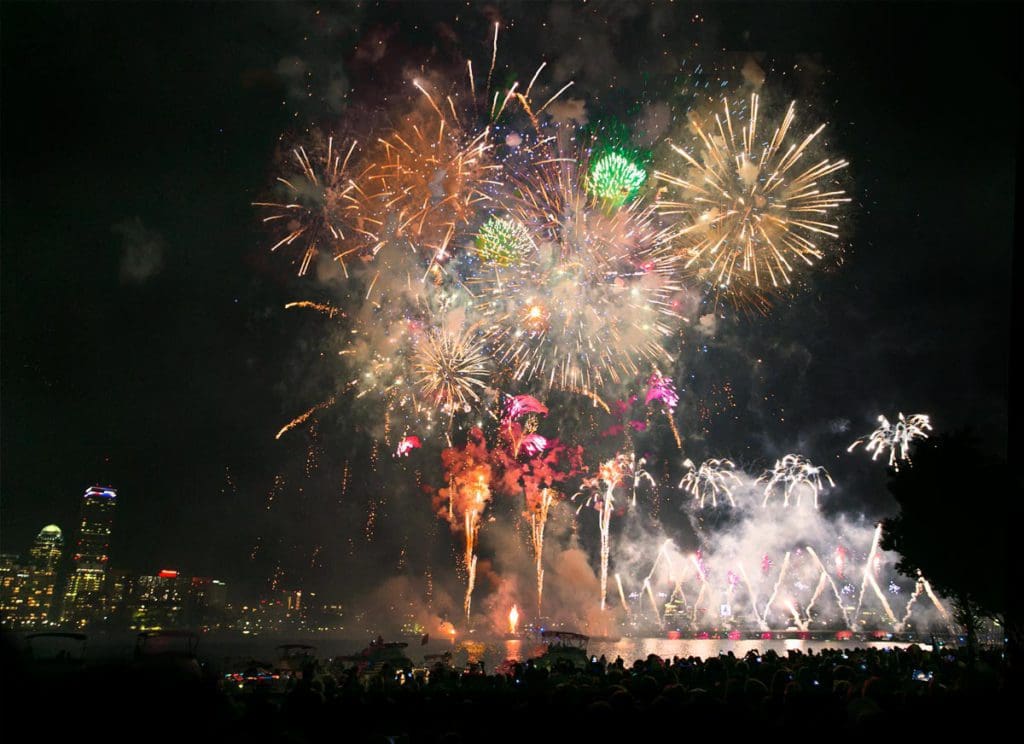 Several, brightly colored, fireworks go off overhead in Boson.