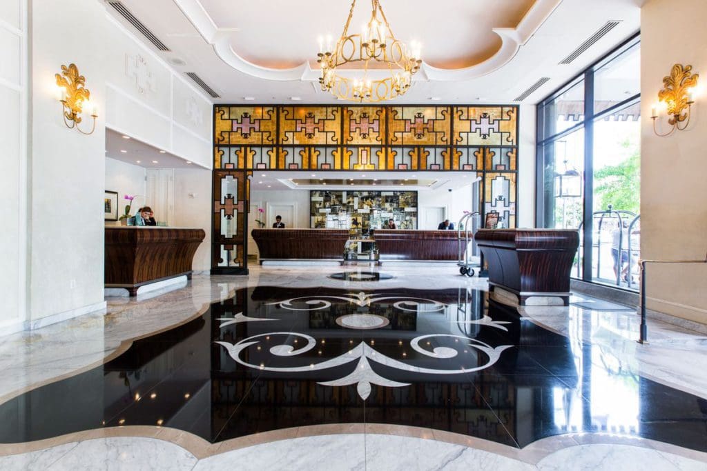 Inside the beautiful lobby of the Loews New Orleans, featuring dark marble floors and bright lighting.