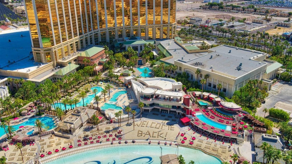 An aerial view of the Mandalay Bay Beach area, featuring several pools and a stretch of beach in front of the resort grounds.