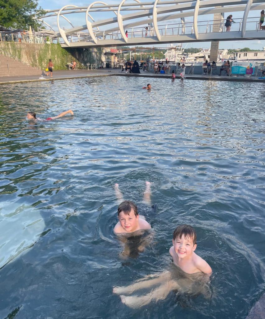 Two boys swim in an outdoor pond in Navy Yard.