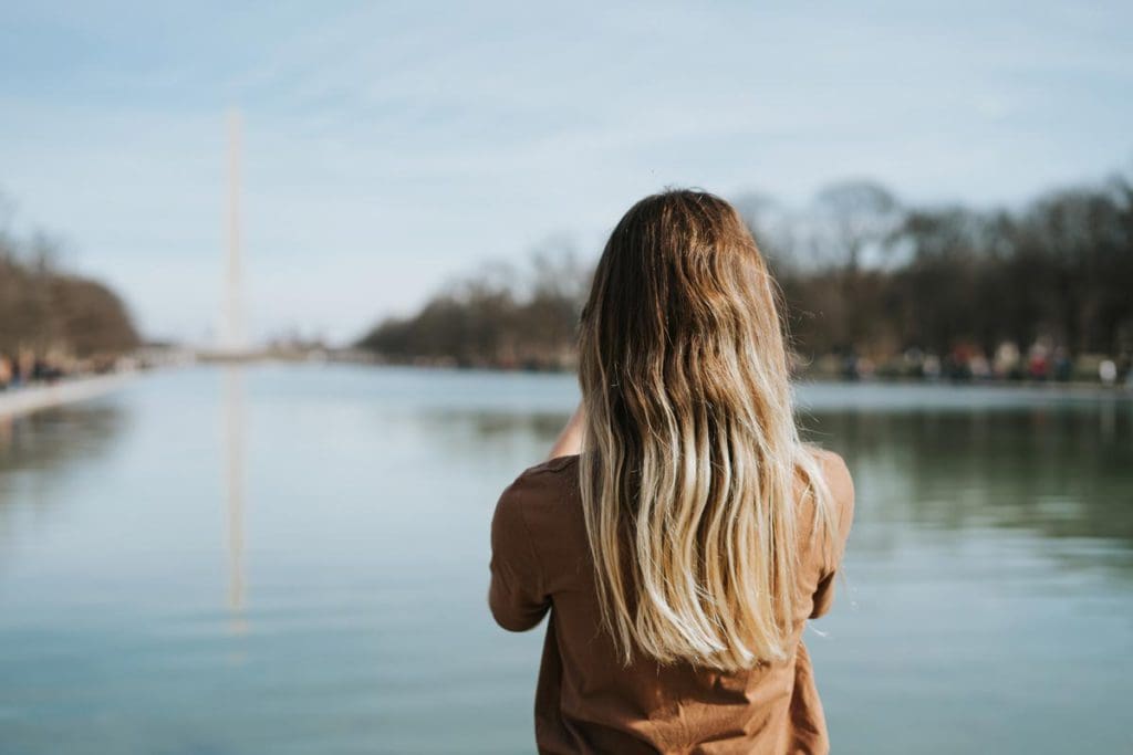 A woman looks down the Washington Mall at the Washington Monument in DC.